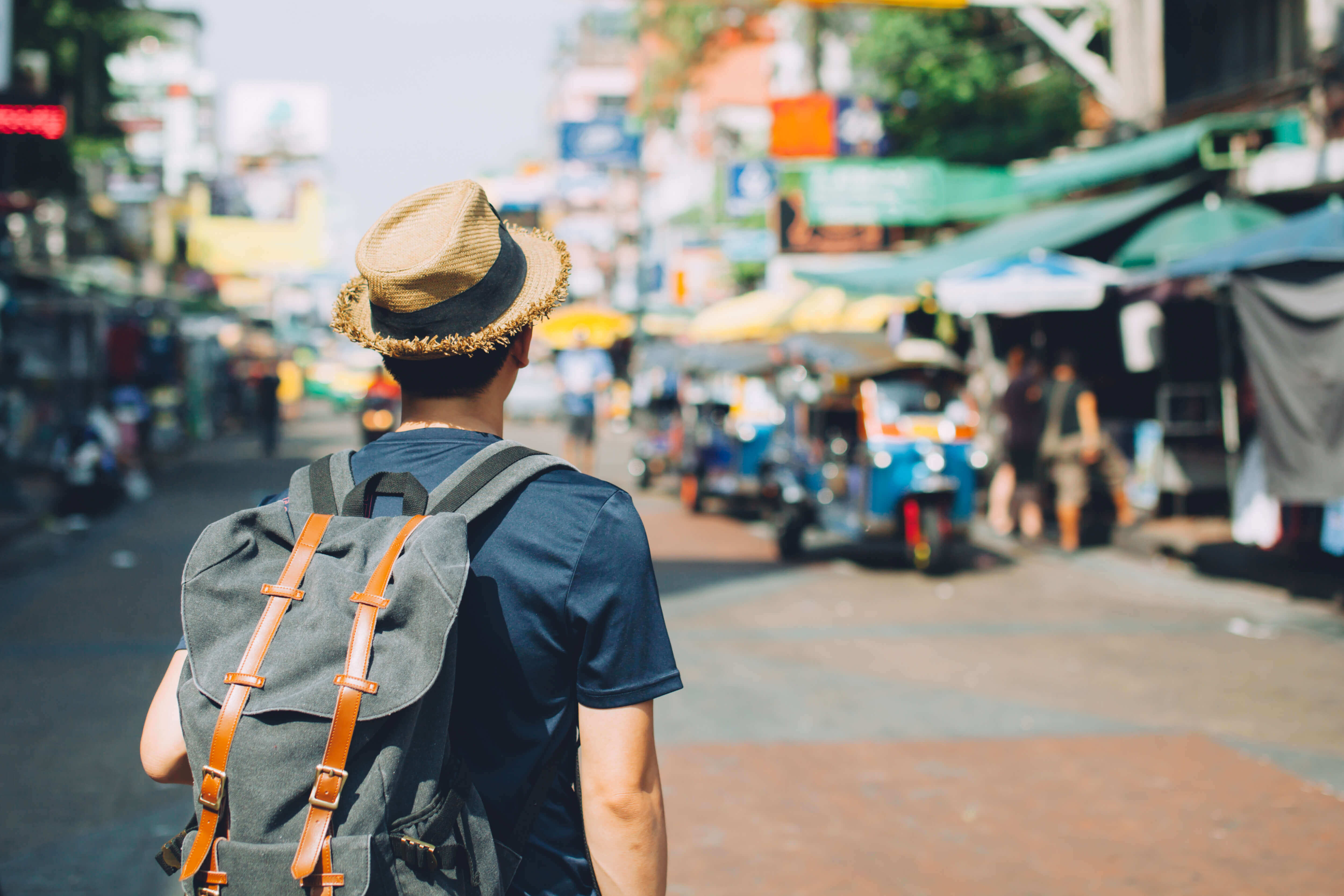 Young Asian traveling backpacker in Khaosan Road outdoor market in Bangkok, Thailand